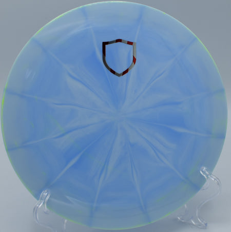 "Lux Vapor Splice disc golf driver with premium vapor plastic, captured mid-flight at Järva DiscGolfPark in Stockholm, Sweden."
