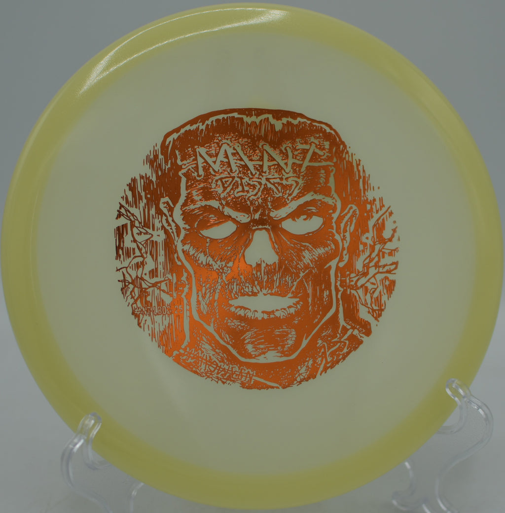 Player using Mint Discs Glow Lobster for a controlled turnover under blacklight at North Cove Disc Golf Course in Marion, North Carolina.