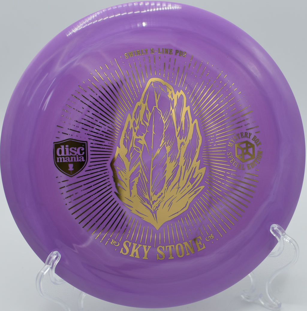 "Sky Stone PD2 distance driver in vibrant colors, photographed on a tee pad at Steilacoom Disc Golf Course."