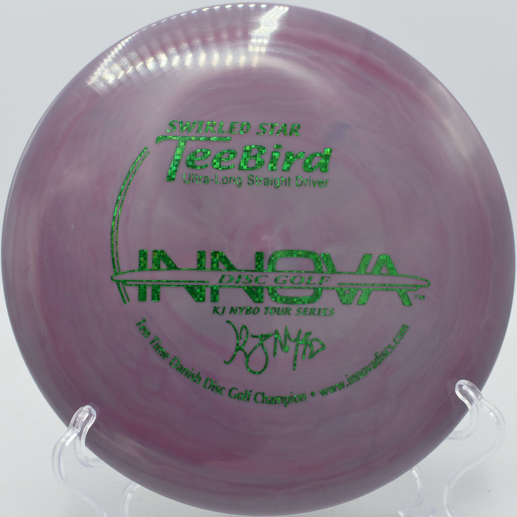 TeeBird in premium Swirly Star plastic parked near the basket at Idlewild Disc Golf Course in Burlington, Kentucky