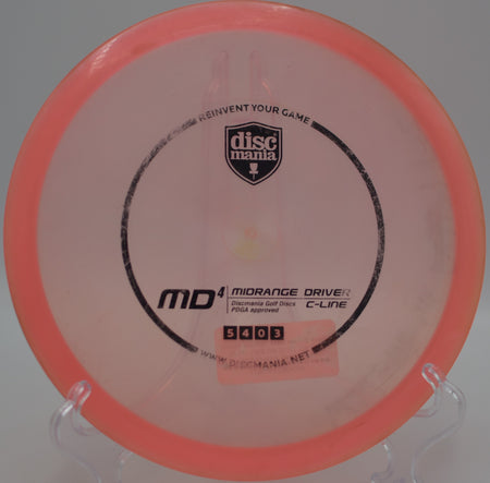 Used C-Line MD4 (Innova Made) resting beside the basket after a straight midrange shot at Blue Ribbon Pines Disc Golf Course in East Bethel, Minnesota.