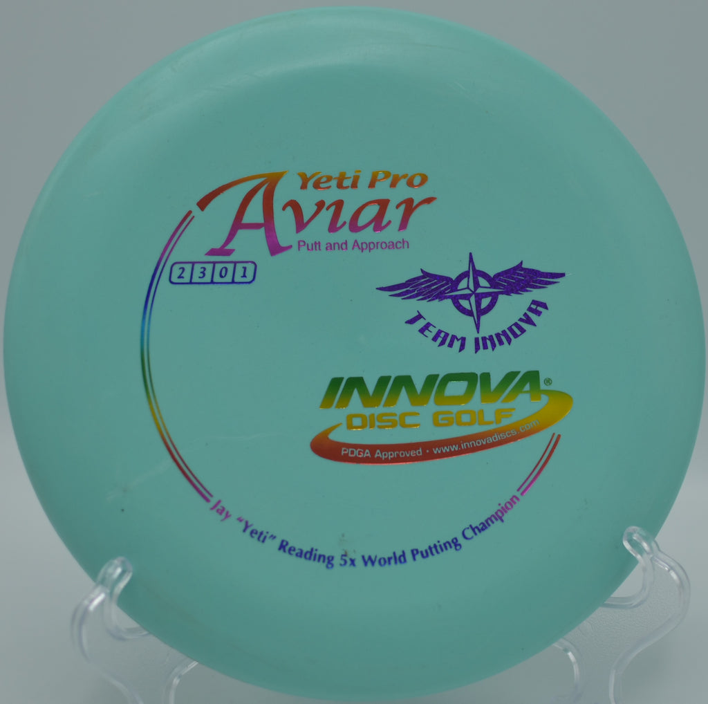 Innova Yeti Pro Aviar (Team Stamp) showing light storage wear with visible scuff marks on the flight plate, photographed at Maple Hill Disc Golf Course in Leicester, Massachusetts.