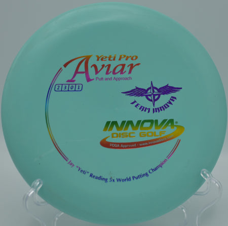 Innova Yeti Pro Aviar (Team Stamp) showing light storage wear with visible scuff marks on the flight plate, photographed at Maple Hill Disc Golf Course in Leicester, Massachusetts.