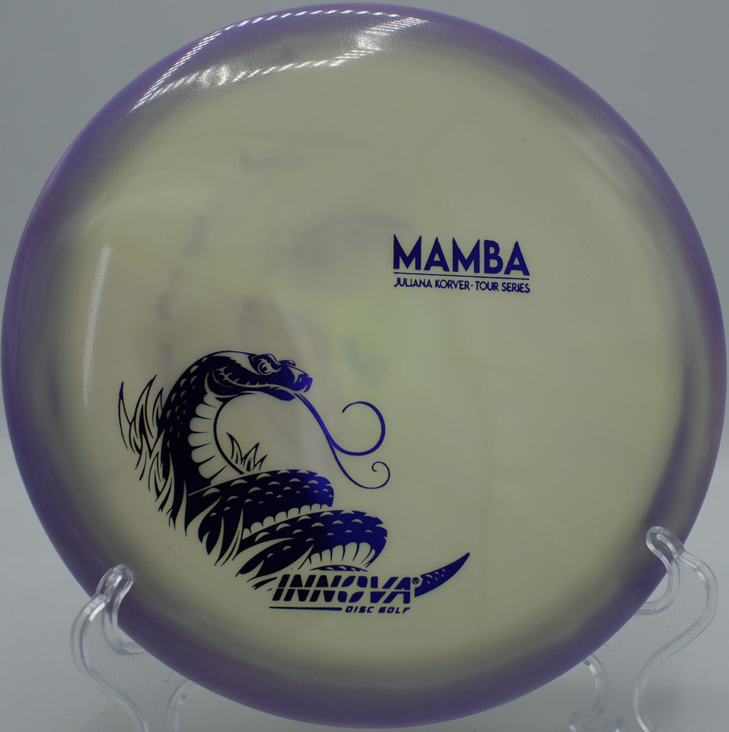 Halo Proto Glow Mamba glowing mid-flight during a smooth hyzer-flip at Trophy Club Disc Golf Course in Trophy Club, Texas.

