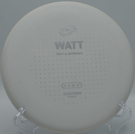 MVP Electron Watt putter resting on the putting green beside basket chains at Willow Metropark Disc Golf Course in New Boston, Michigan