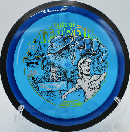 MVP Proton Trail glowing with Halloween-themed artwork as it carves a perfect anhyzer line through dense woods at Buckhorn Disc Golf Course in New Hill, North Carolina.