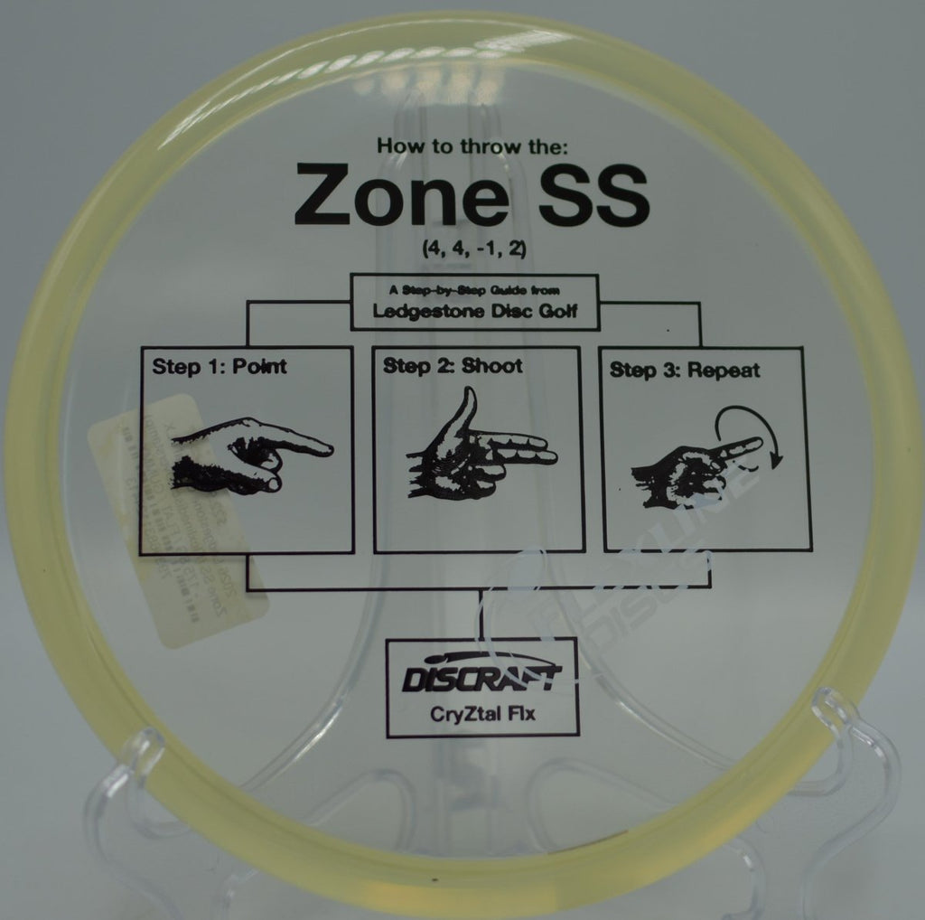Discraft Zone SS in CryZtal FLX plastic landing softly near the basket on a finesse backhand at McPherson Park Disc Golf Course in Flagstaff, Arizona