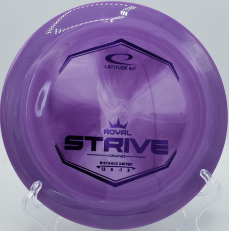 Latitude 64 Grand Strive high-speed distance driver resting in fairway grass at Milo McIver Disc Golf Course in Estacada, Oregon