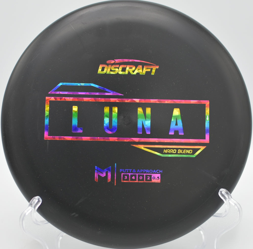 Discraft Hard Blend Luna floating straight toward the basket during a calm round at Pier Park Disc Golf Course in Portland, Oregon.