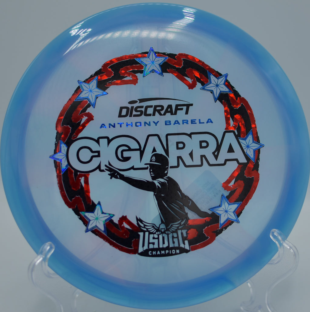 Swirled Z-Swirl Cigarra set on the wooded fairway at The Ruins DGC in Newark, DE, built for controlled turnovers and straight lines.