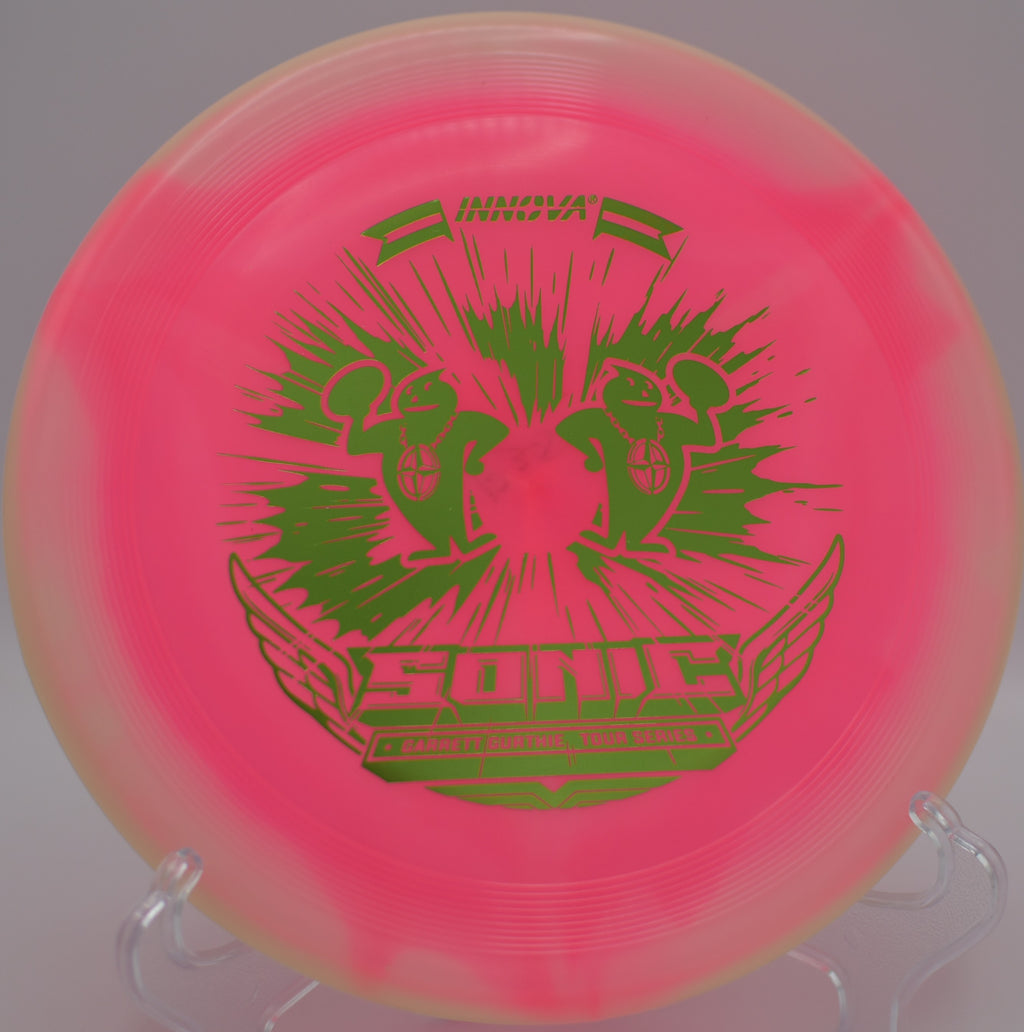 Garrett Gurthie Halo Glow Champion Sonic – 2023 Tour Series spinning on a floaty turnover approach at Lake Olmstead Park Disc Golf Course in Fort Myers, Florida, glowing brightly as it settles near the basket.