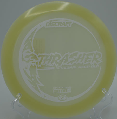 Mega Glow Z Thrasher glowing bright on a full-power drive at Blue Ribbon Pines Disc Golf Course in East Bethel, Minnesota.