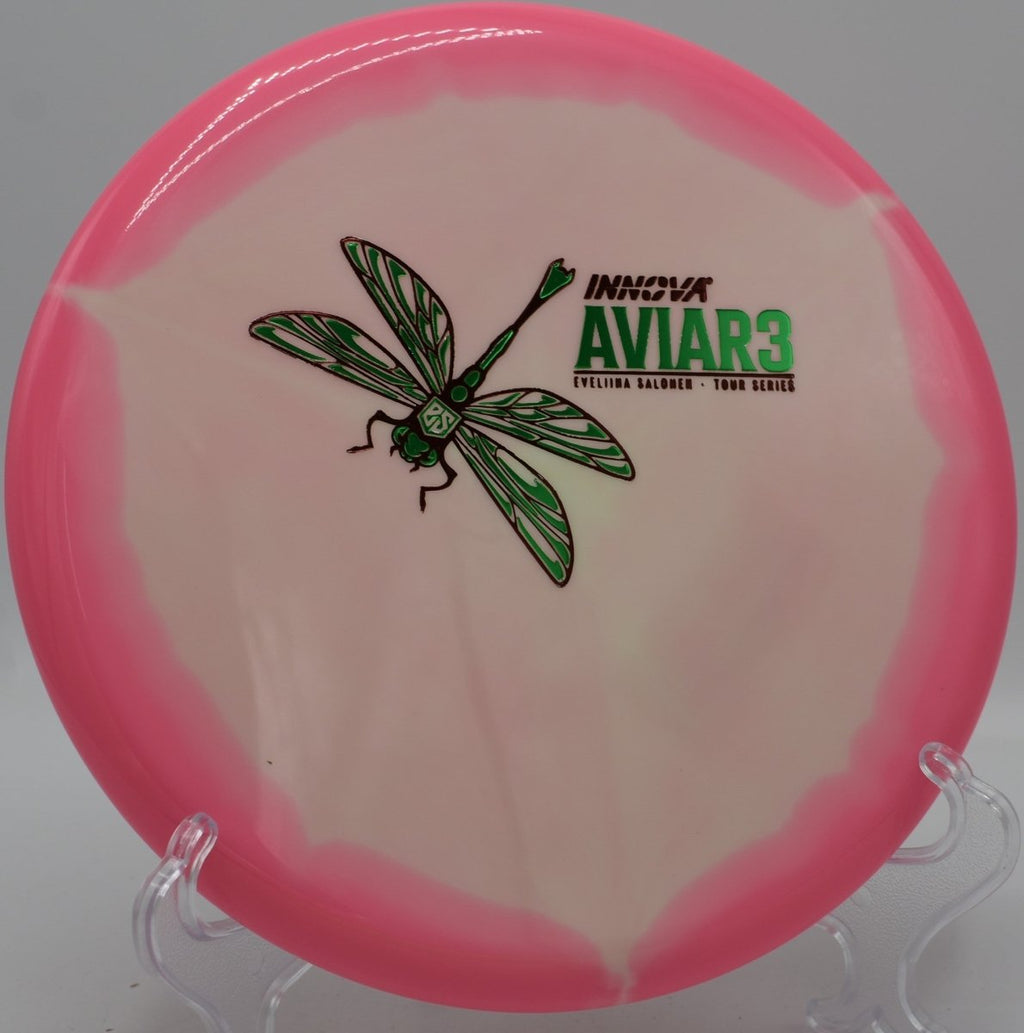Eveliina Salonen Aviar3 Tour Series putter lying beside the basket pole after a controlled hyzer upshot at Coon Rapids Dam Disc Golf Course in Coon Rapids, Minnesota