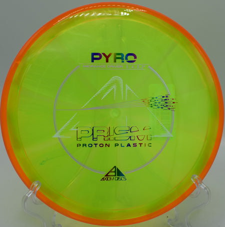 A player throwing the Prism Proton Pyro from a tee pad at Blue Ribbon Pines Disc Golf Course in East Bethel, Minnesota, highlighting its precision and glide.