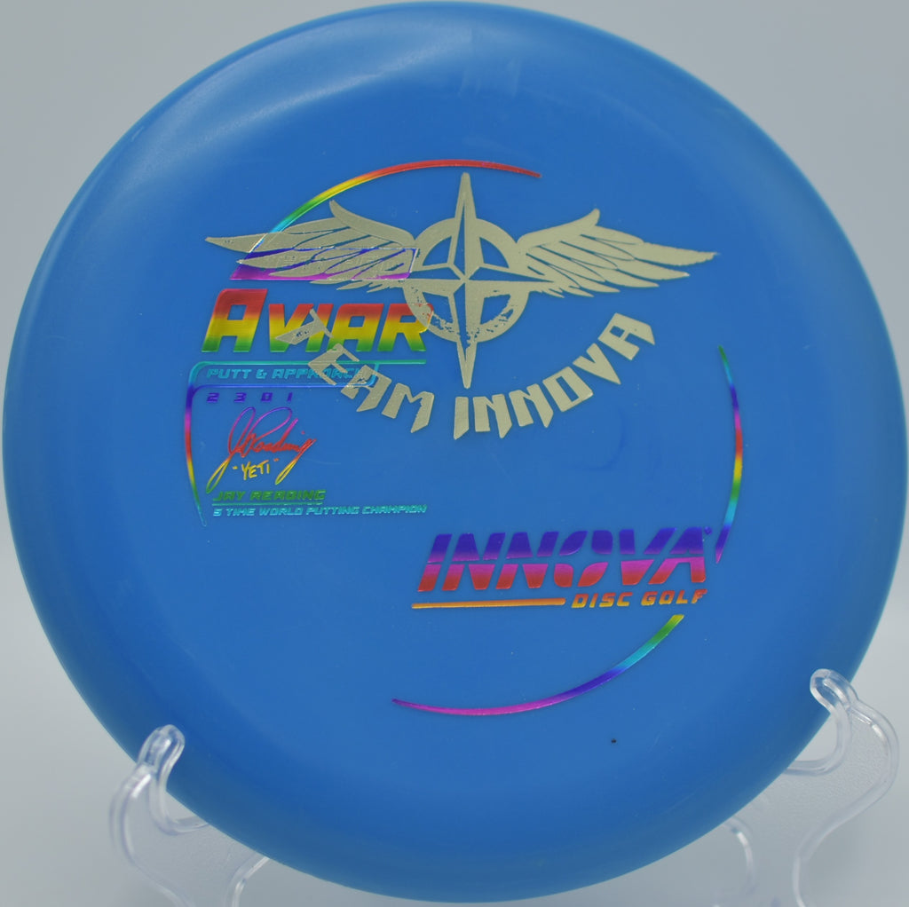 Lightly worn Yeti Pro Aviar Team Stamp showing subtle shelf marks on the rim, staged near the putting green at North Cove Disc Golf Course in Marion, North Carolina.