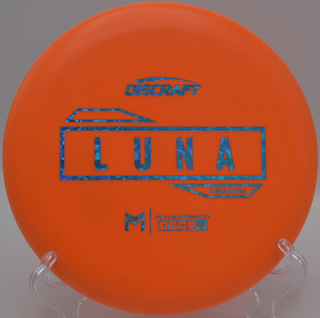 Discraft Hard Blend Luna resting beside the cage after a precise approach at Dabney State Park Disc Golf Course in Troutdale, Oregon.