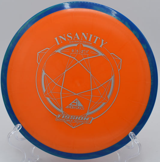 The Fission Insanity disc mid-flight on the fairway at Hornet’s Nest Disc Golf Course in Charlotte, North Carolina, demonstrating its glide and slight turn for controlled distance throws.