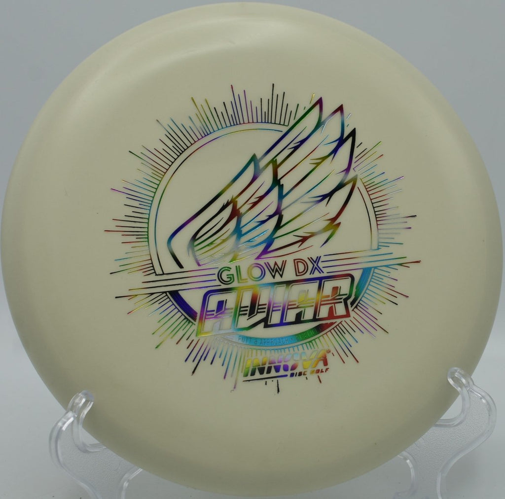 Innova DX Glow Aviar putter positioned for a straddle putt under lights at West Park Disc Golf Course in Joliet, Illinois