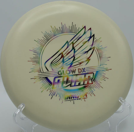 Innova DX Glow Aviar putter positioned for a straddle putt under lights at West Park Disc Golf Course in Joliet, Illinois