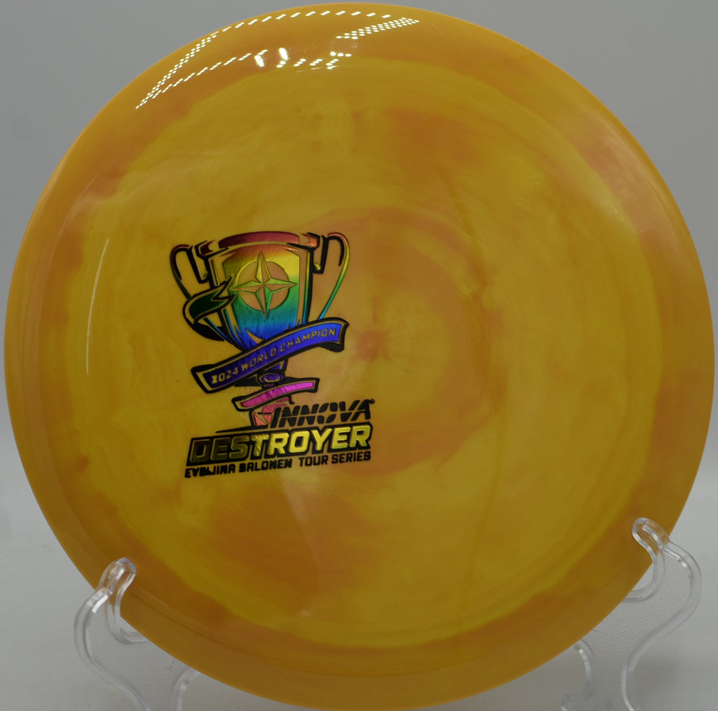 Ohn Scoggins Tour Series Destroyer resting on the tee pad at Harmony Bends Disc Golf Course in Columbia, Missouri, ready for high-speed distance drives and headwind shots