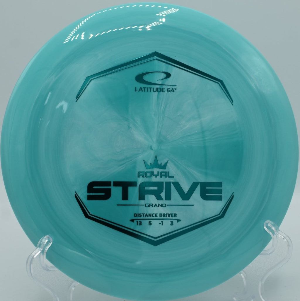 Grand plastic Strive distance driver resting near basket chains at Blue Ribbon Pines Disc Golf Course in East Bethel, Minnesota