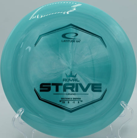 Grand plastic Strive distance driver resting near basket chains at Blue Ribbon Pines Disc Golf Course in East Bethel, Minnesota