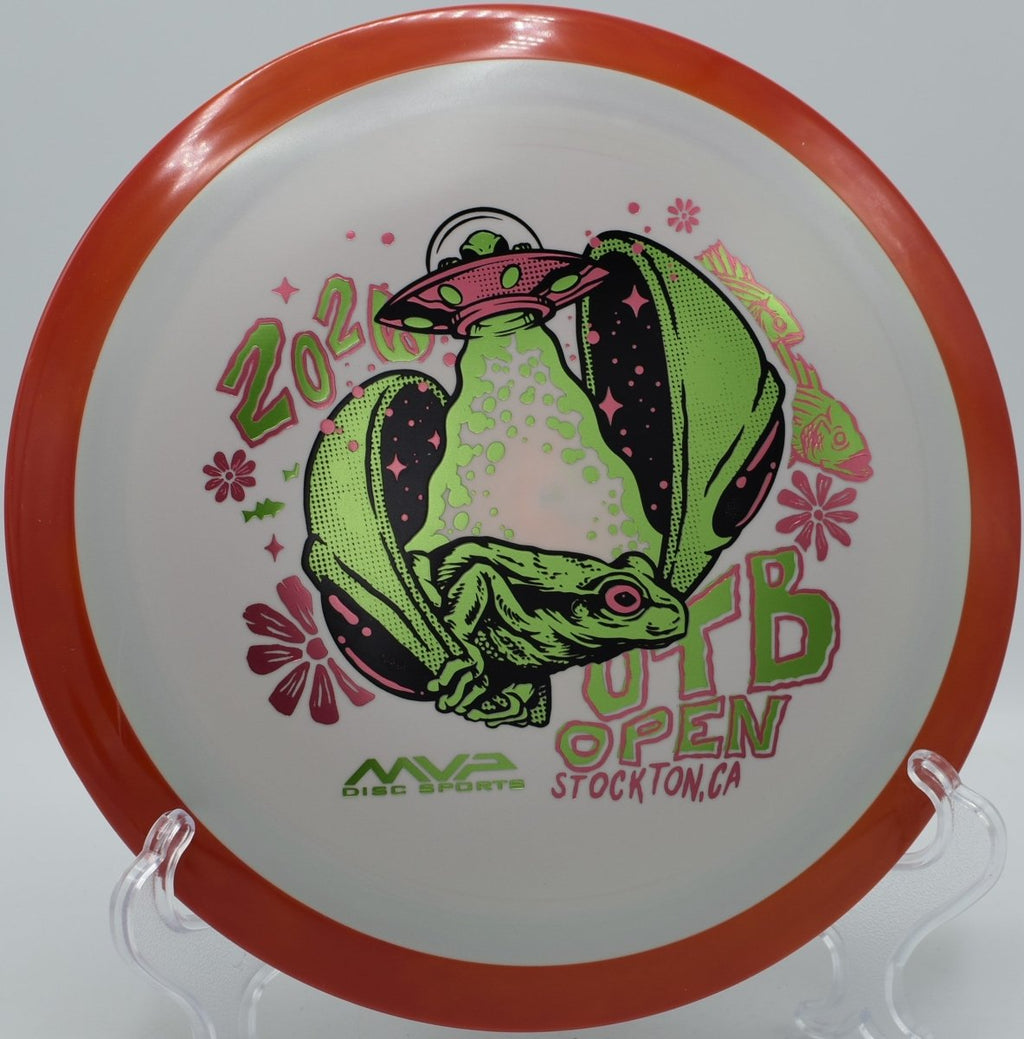 Axiom OTB Open Delirium Fission driver resting near basket chains at Milo McIver Disc Golf Course in Estacada, Oregon