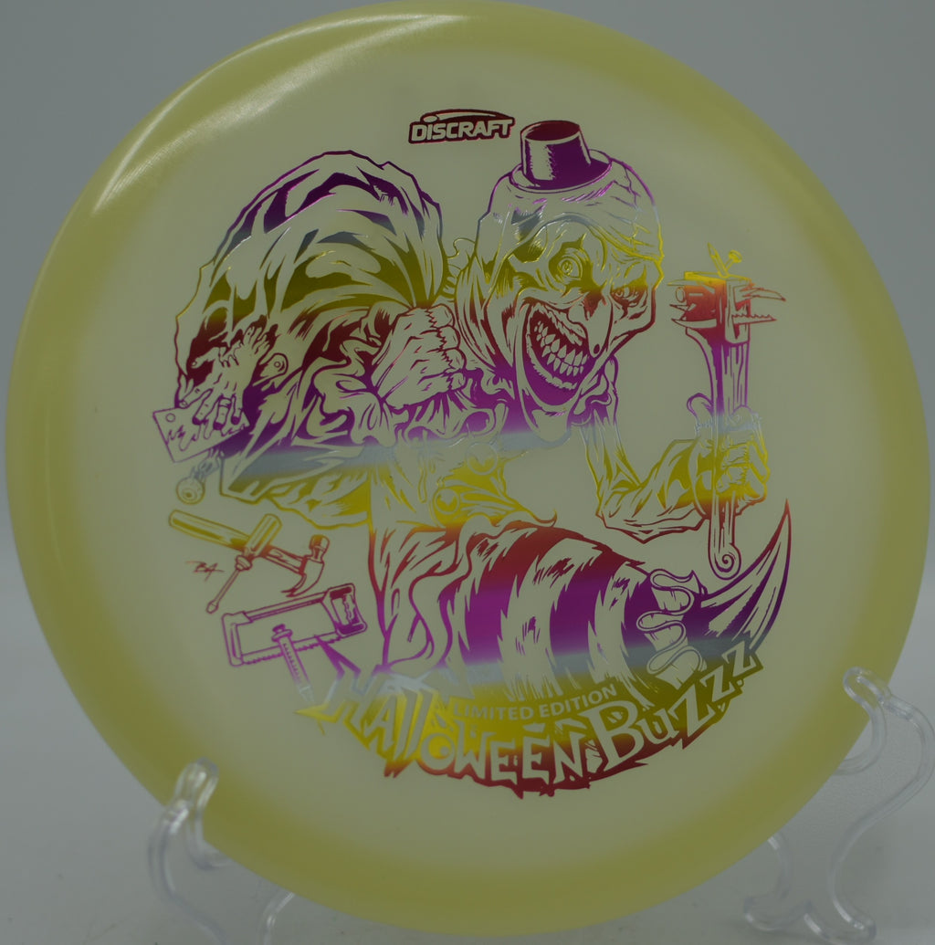 2025 Halloween Mega Glo Single Stamped Buzzz glowing mid-flight at Reservoir Park Disc Golf Course in Southern Pines, North Carolina.