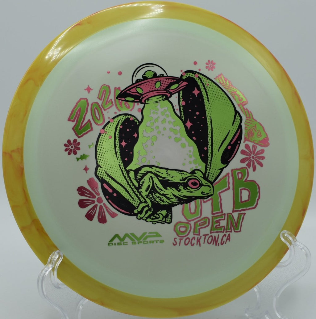 2026 OTB Open Fission Delirium distance driver on grass beside tee sign at The Canyons Disc Golf Course in Lockport, Illinois