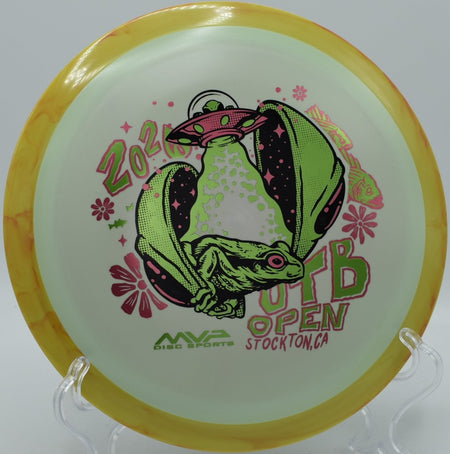 2026 OTB Open Fission Delirium distance driver on grass beside tee sign at The Canyons Disc Golf Course in Lockport, Illinois