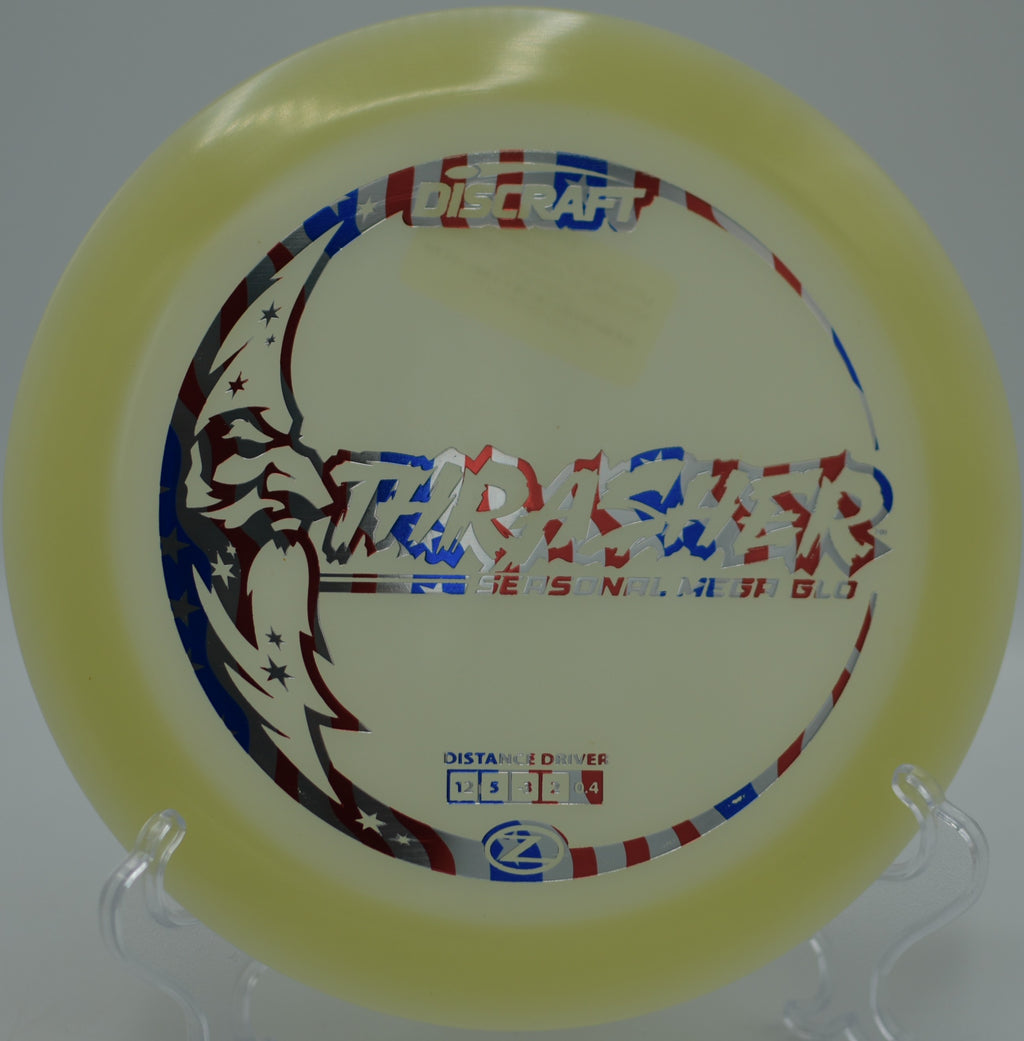 Mega Glow Z Thrasher glowing along a wooded fairway at Rollin Ridge Disc Golf Course in Reedsville, Wisconsin.