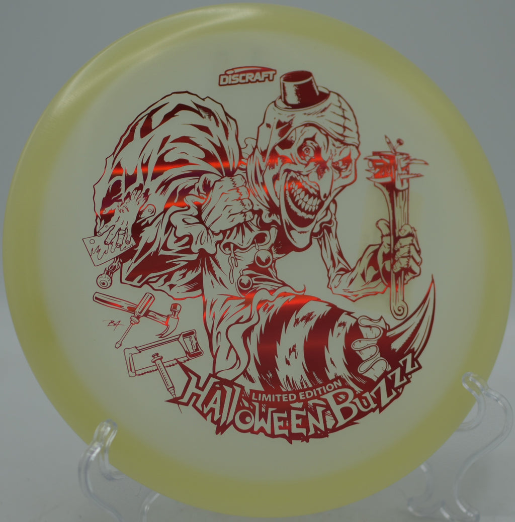 Discraft 2025 Mega Glo Halloween Buzzz single stamp gliding bright through the woods at Rolling Pines Disc Golf Course in Wilkesboro, North Carolina.