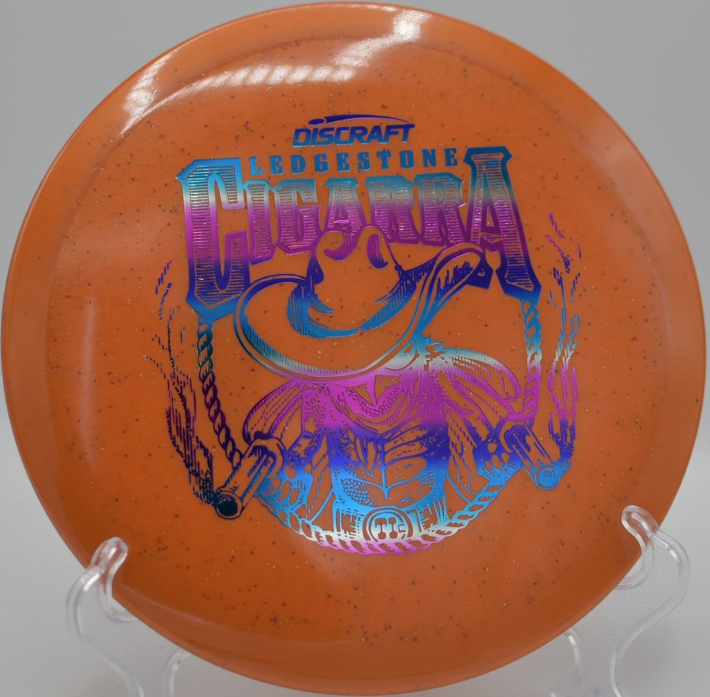 Discraft Cigarra Ti Sparkle plastic catching the light after a precision hyzer flip at Panther Creek Disc Golf Course in Morristown, Tennessee