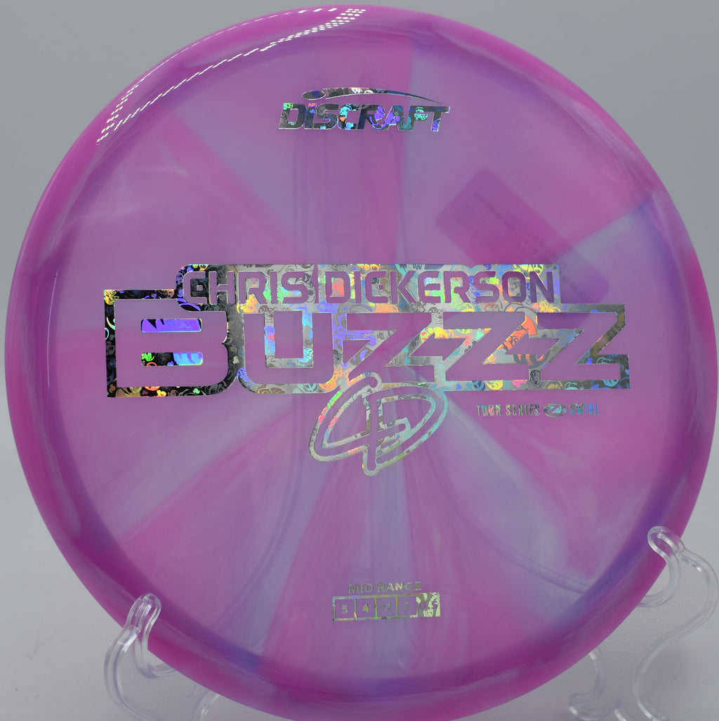 Mid-flight Z Swirl Buzzz sailing above grass at DeLaveaga Disc Golf Course in Santa Cruz, California.

