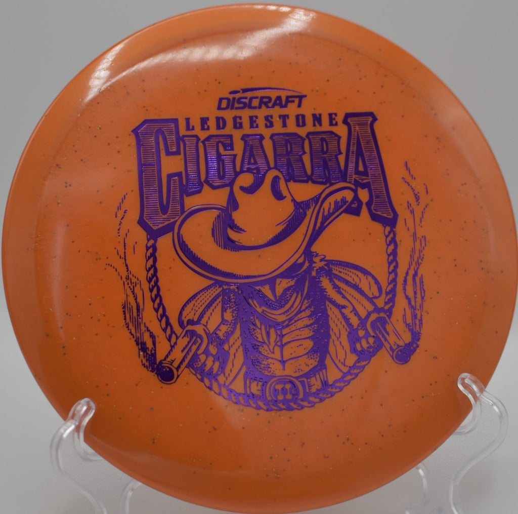 2026 Ledgestone Series Ti Sparkle Cigarra fairway driver powering a controlled drive on rolling terrain at North Cove Disc Golf Course in Marion, North Carolina