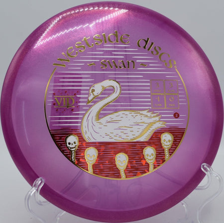 VIP Glimmer Swan putter lying beside the basket pole after a glidey turnover approach at Greenfield Park Disc Golf Course in Mesa, Arizona