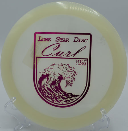 "Close-up of the Lone Star Curl disc resting near a basket at SeaTac Disc Golf Course in SeaTac, Washington, highlighting its premium design."
