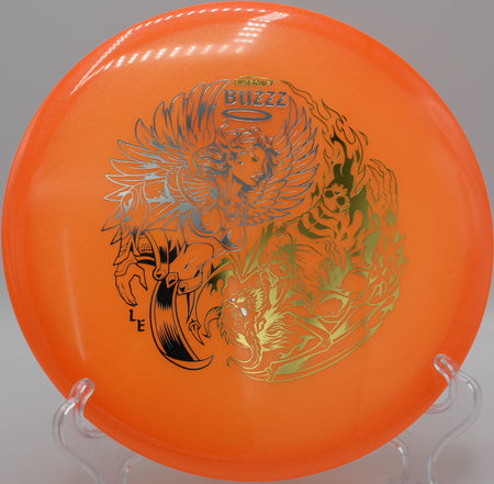 Discraft Colorshift Z Glo Buzzz resting on the fairway at Maple Hill Disc Golf Course in Leicester, Massachusetts, with premium plastic and stable flight performance.

