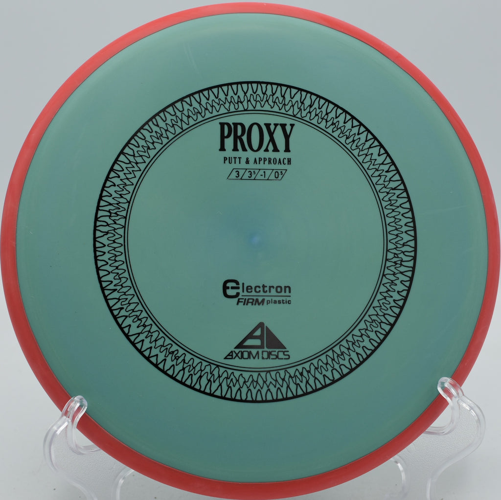Axiom Electron Firm Proxy dependable putter settling beside the basket at DeLaveaga Disc Golf Course in Santa Cruz, California.