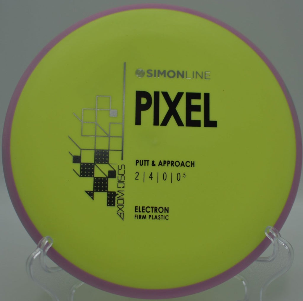MVP Electron Firm Pixel disc golf putter resting beside basket chains after a soft approach at Veterans Memorial Park Disc Golf Course in Burlington, North Carolina