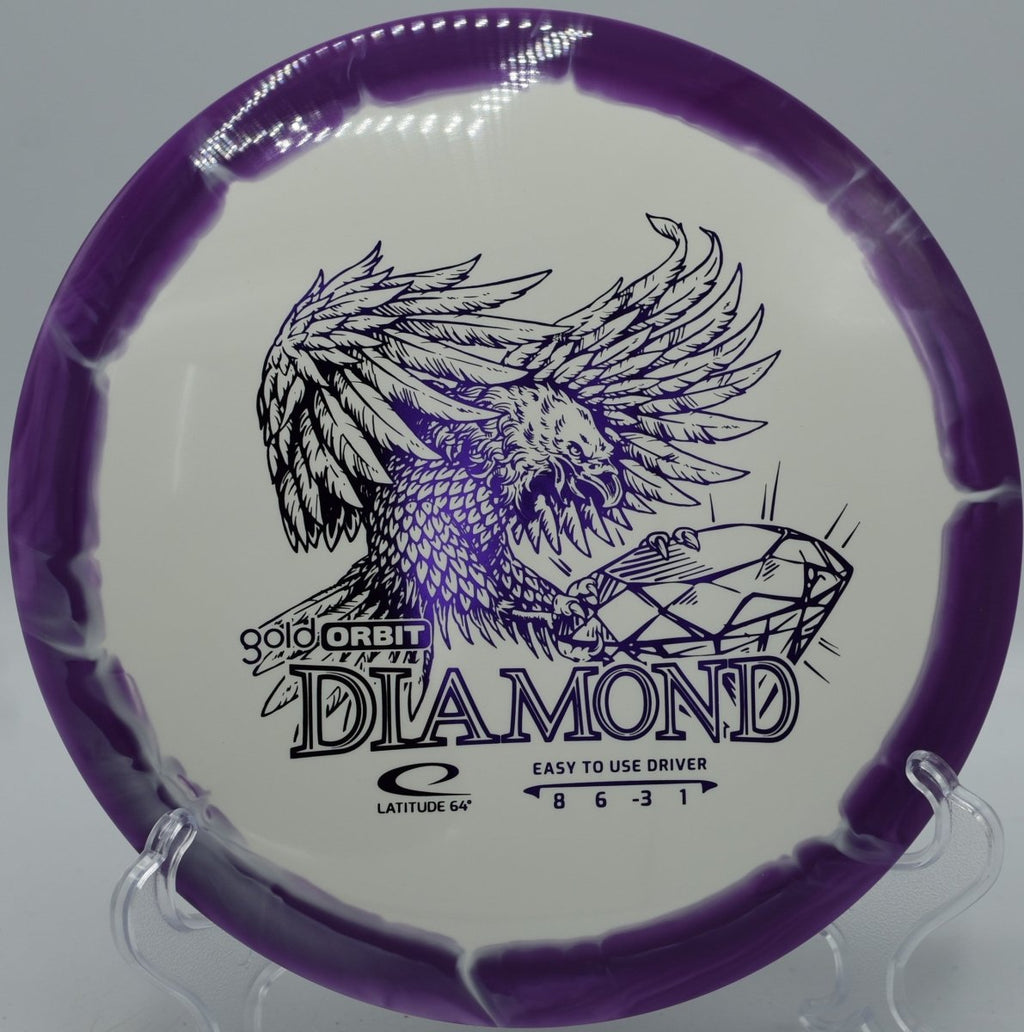 Gold Orbit Diamond fairway driver photographed on tee pad at Pier Park Disc Golf Course in Portland, Oregon