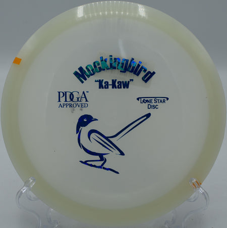 "Lone Star Glow Mockingbird gliding gracefully over the fairway at Morley Field Disc Golf Course in San Diego, California, showcasing its control."
