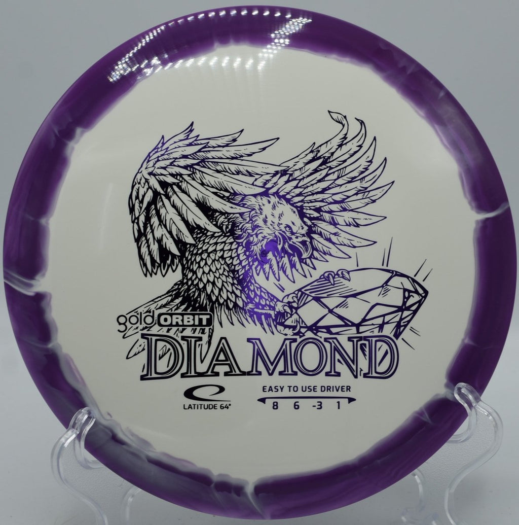 Latitude 64 Gold Orbit Diamond driver resting near basket at Smugglers Notch Brewster Ridge Disc Golf Course in Jeffersonville, Vermont