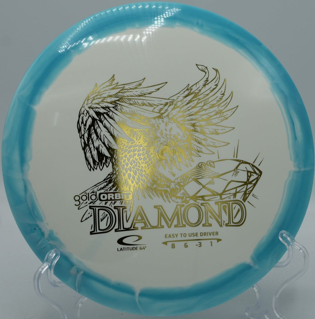 Gold Orbit Diamond understable fairway driver beside basket at Eagles Crossing Disc Golf Course in Hawk Point, Missouri