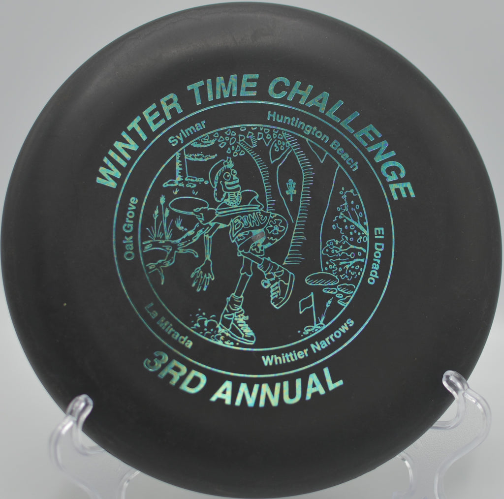 Black 2-Ring San Marino Microbead Aviar w/Pat# floating smoothly toward the basket at DeLaveaga Disc Golf Course in Santa Cruz, California, during a calm morning putting session.