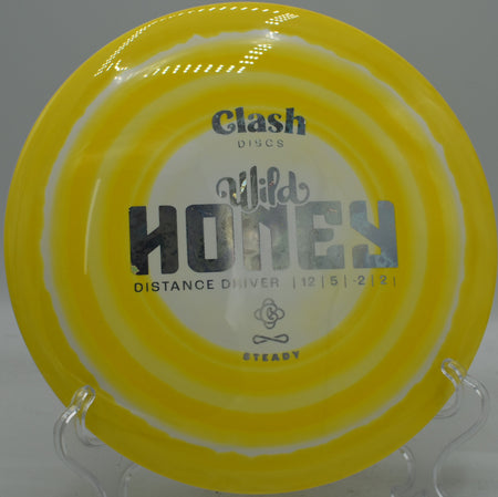 Clash Wild Honey in Steady plastic carving a smooth hyzer-flip that turns slowly before landing clean at Harmony Bends.

