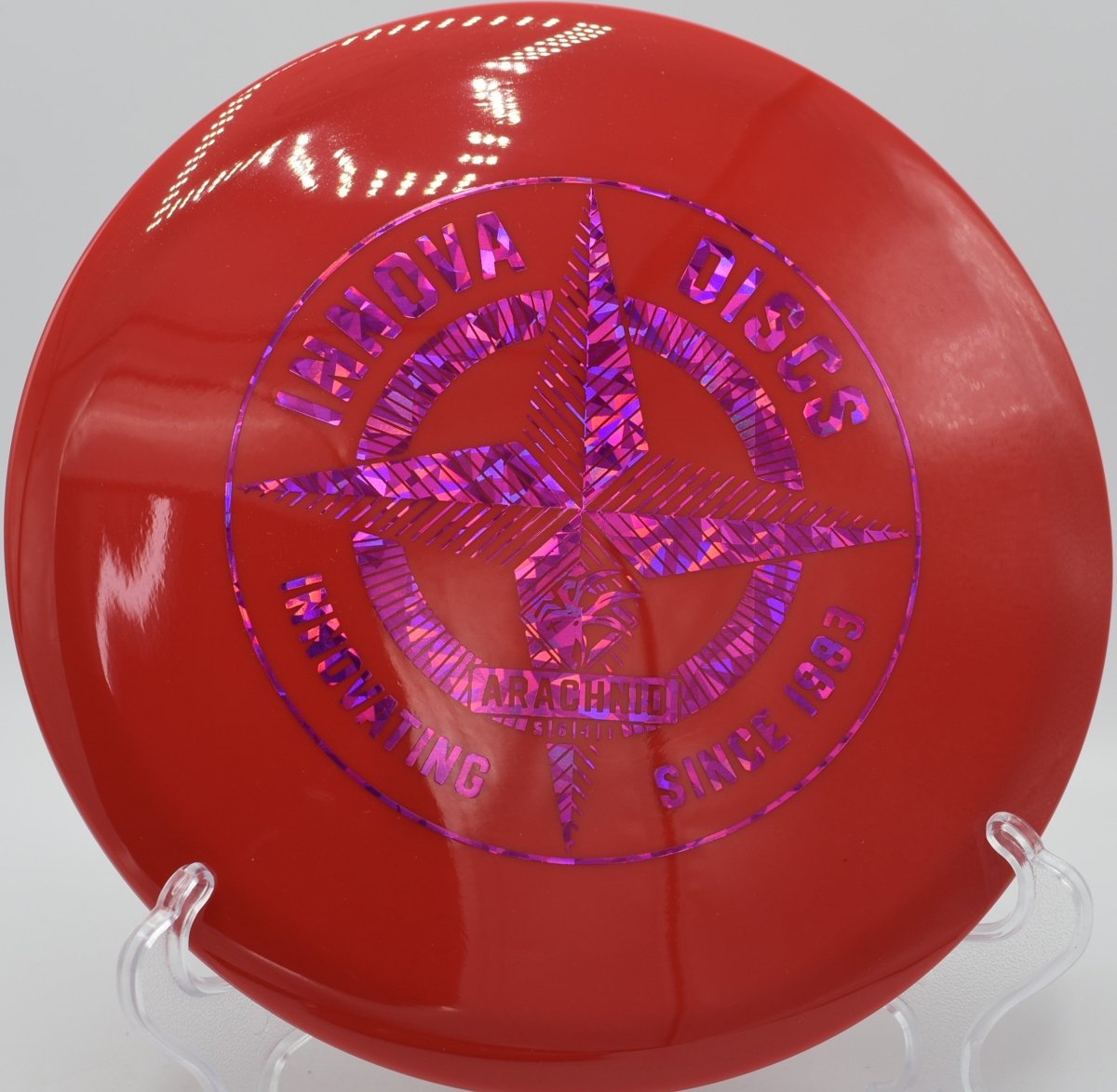 Innova Protostar Arachnid midrange resting beside chains after a touch forehand approach at Freedom Park Disc Golf Course in Williamsburg, Virginia