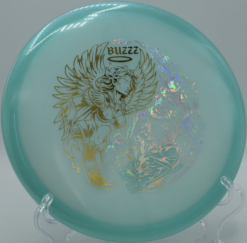 Discraft Colorshift Glo Buzzz resting near the pin at Sabattus Disc Golf Course in Maine, ideal for controlled approaches in glow rounds.

