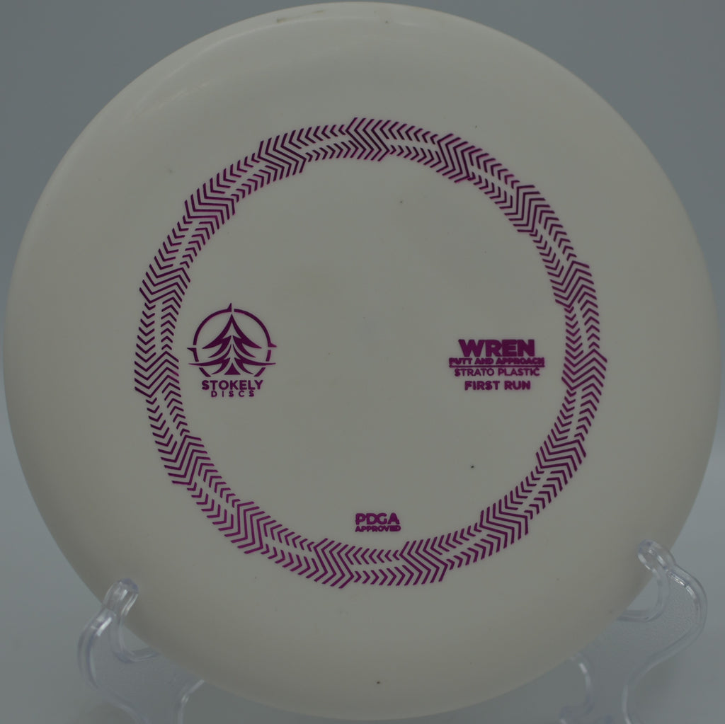 Stokely Strato Wren resting under the pin after a clean release at Burchfield Park Disc Golf Course in Holt, Michigan.