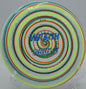 Close-up of an I-Dye Star Wraith mid-flight at Maple Hill Disc Golf Course in Leicester, Massachusetts